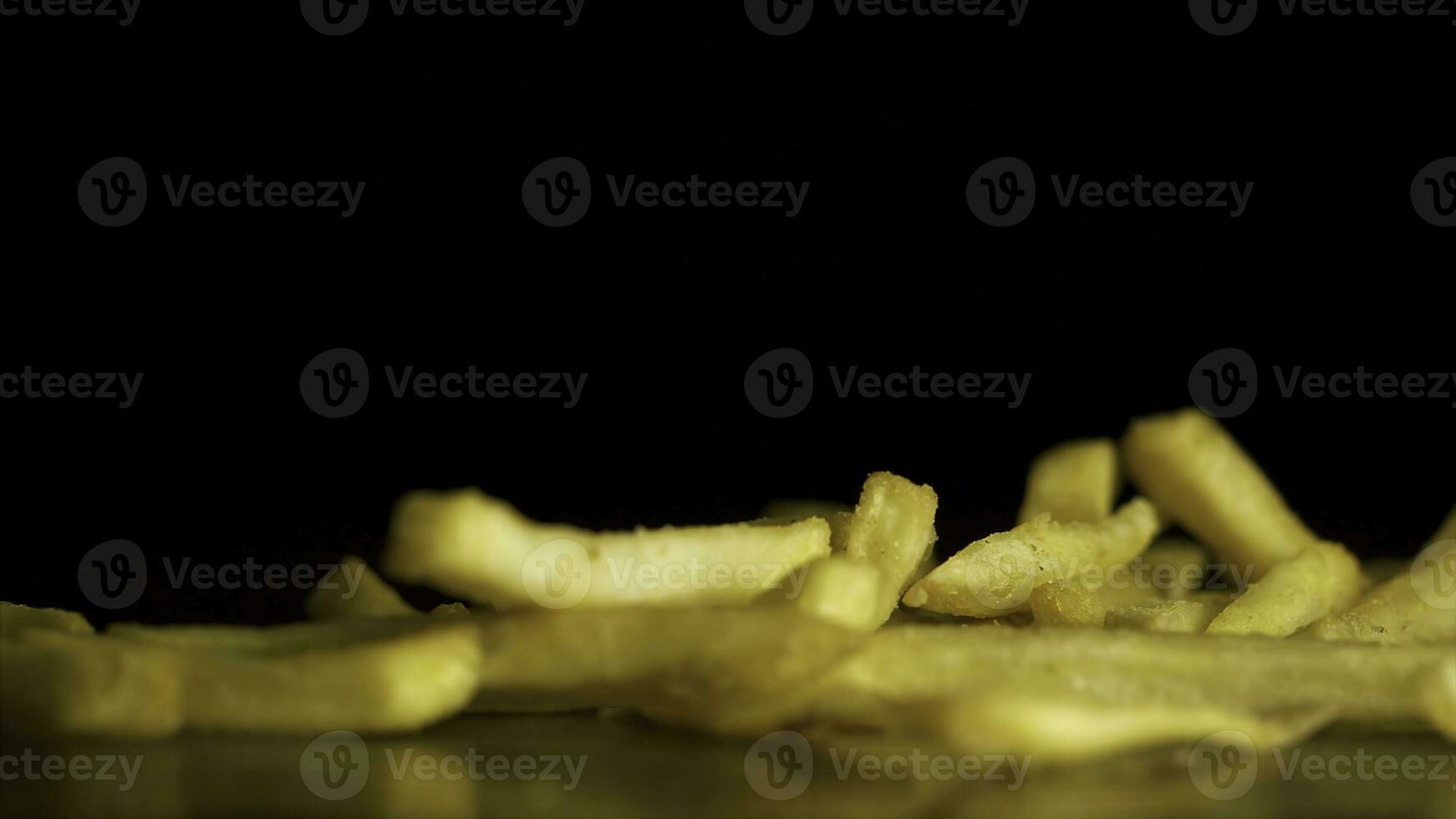 French fries fall on the table isolated on black background. Fastfood. French fries. Flying fried potatoes on black background. Pile of french fries over black background photo