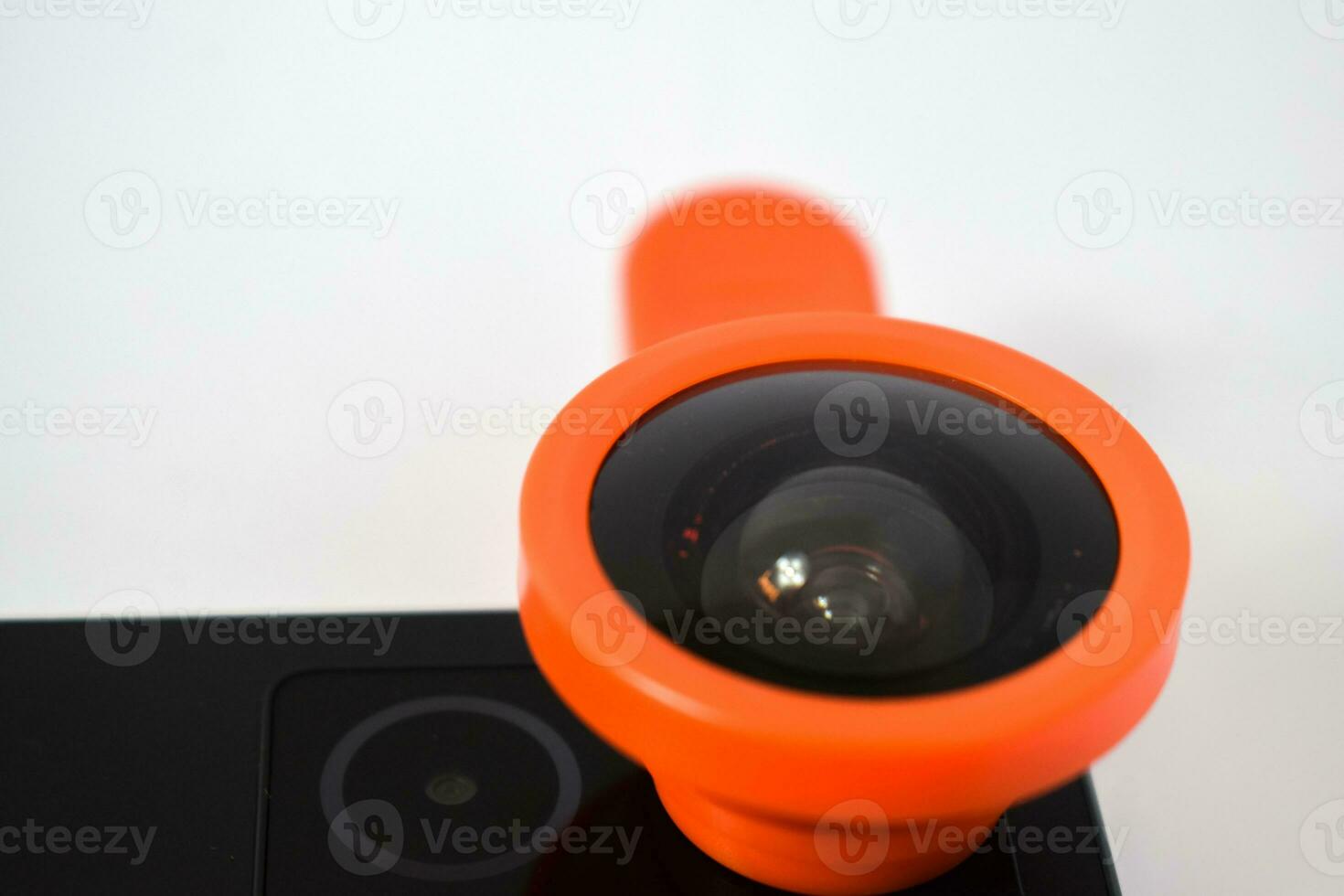 Close up Clip on fisheye lens on black smartphone, extension fish eye lens on smartphone  camera isolated on white background photo