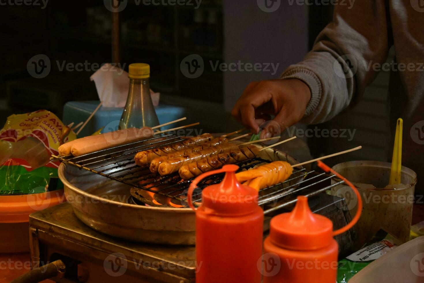 un comerciante interrogatorio intenso embutido, Indonesia calle comida foto