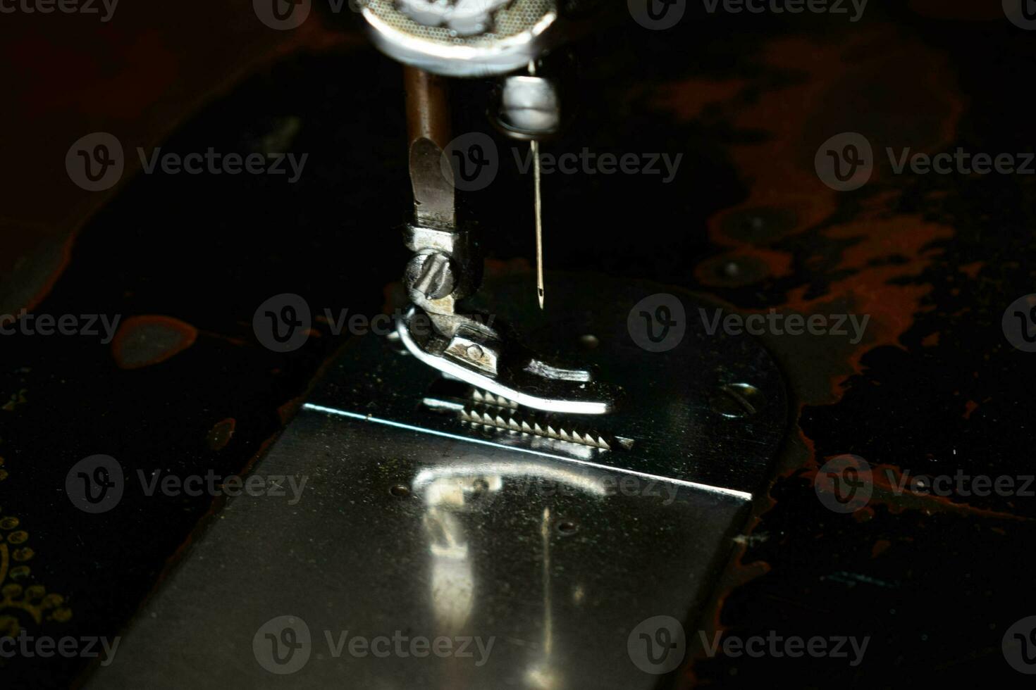 Close up sewing machine with needle on wood table, antique sewing machine with dust photo