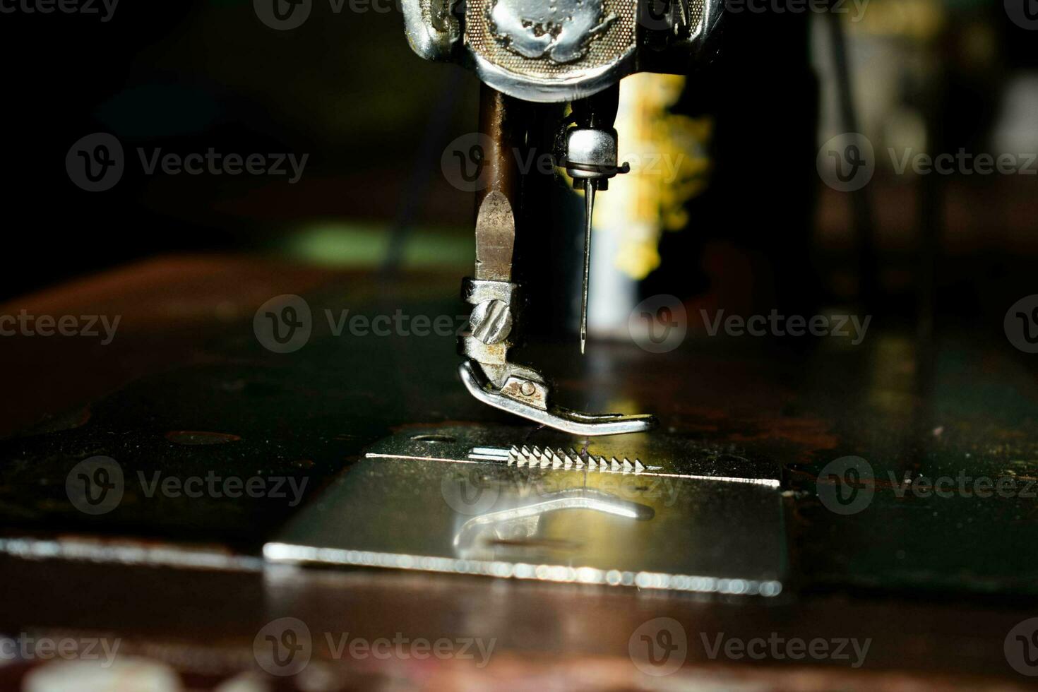 Close up sewing machine with needle on wood table, antique sewing machine with dust photo