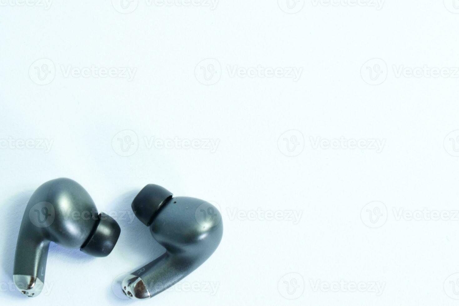 Silver wireless headset or earphone is called TWS, true wireless strereo for playing music without cable jack audio isolated on whote background photo