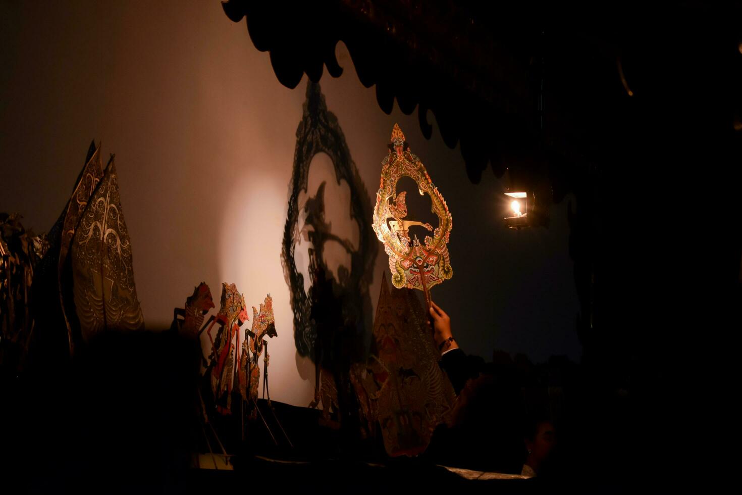 A man perform with wayang or traditional javanese puppet on stage at night. Tuban, Indonesia - 22 September, 2023. photo