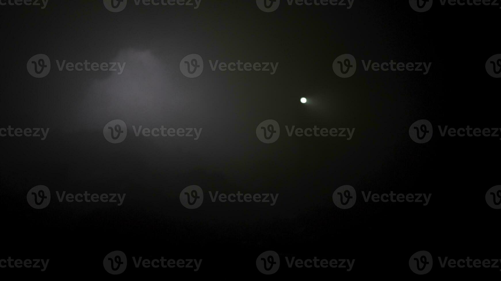 Dark and mystical landscape of someone moving inside the dark foggy cave with a torch in his hands. Stock footage. Man holding a torch in the underground cave. photo