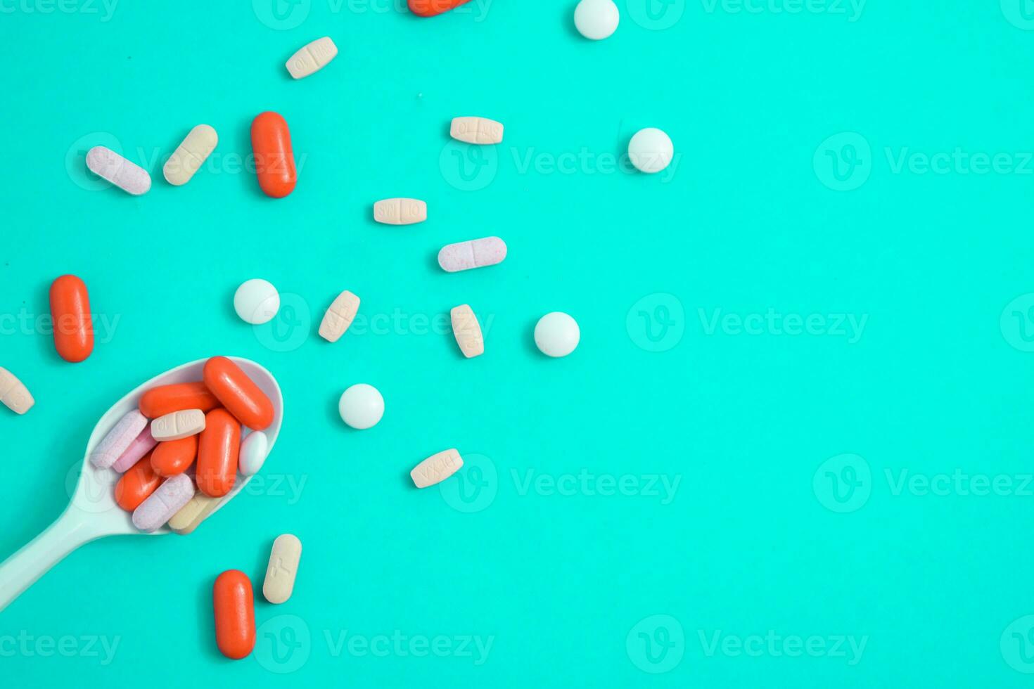 Colorful Medicine Pills in White spoon on green tosca background, supplement, vitamin, colorful photo