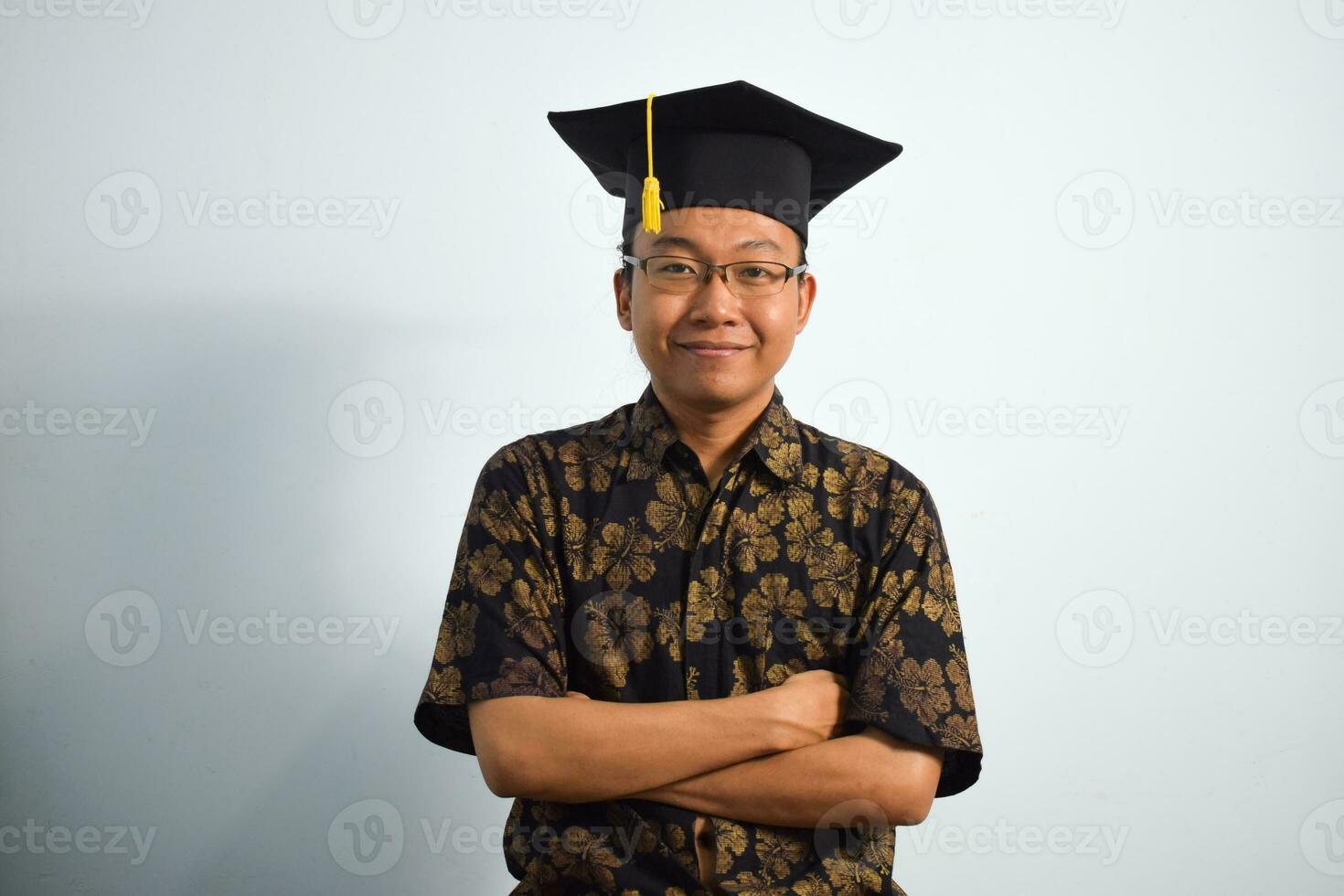 expresivo de adulto Indonesia masculino vestir batik, toga taza o graduación sombrero y los anteojos aislado en blanco fondo, expresiones de retrato graduación foto