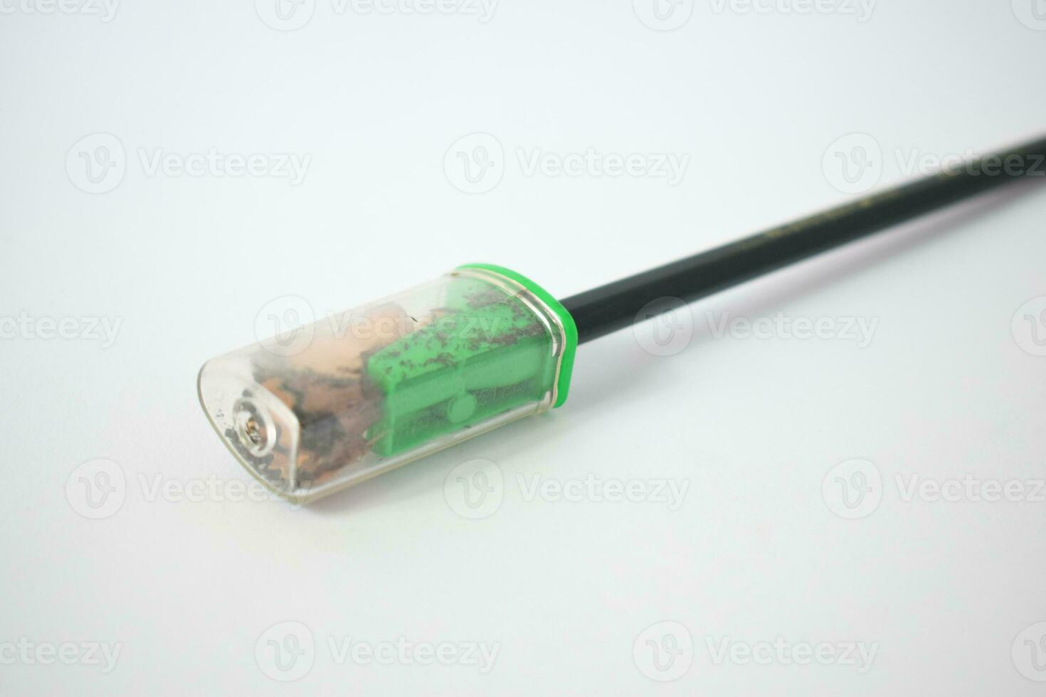 green pencil sharpener and dark green pencils on white background photo