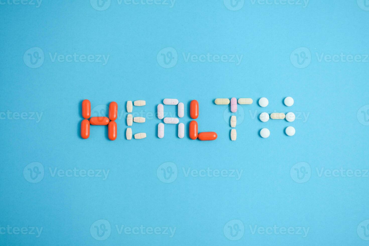 health word from Colorful Medicine Pills isolated on blue background, supplement, vitamin, colorful photo