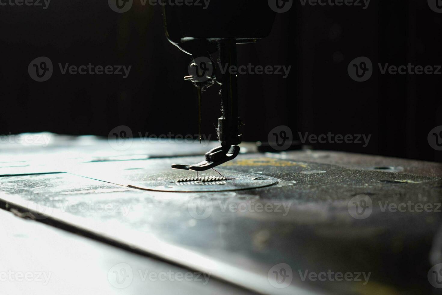 Close up sewing machine with needle on wood table, antique sewing machine with dust photo