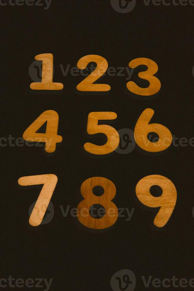 Wooden numbers on a black background. Numbers from zero to nine. photo