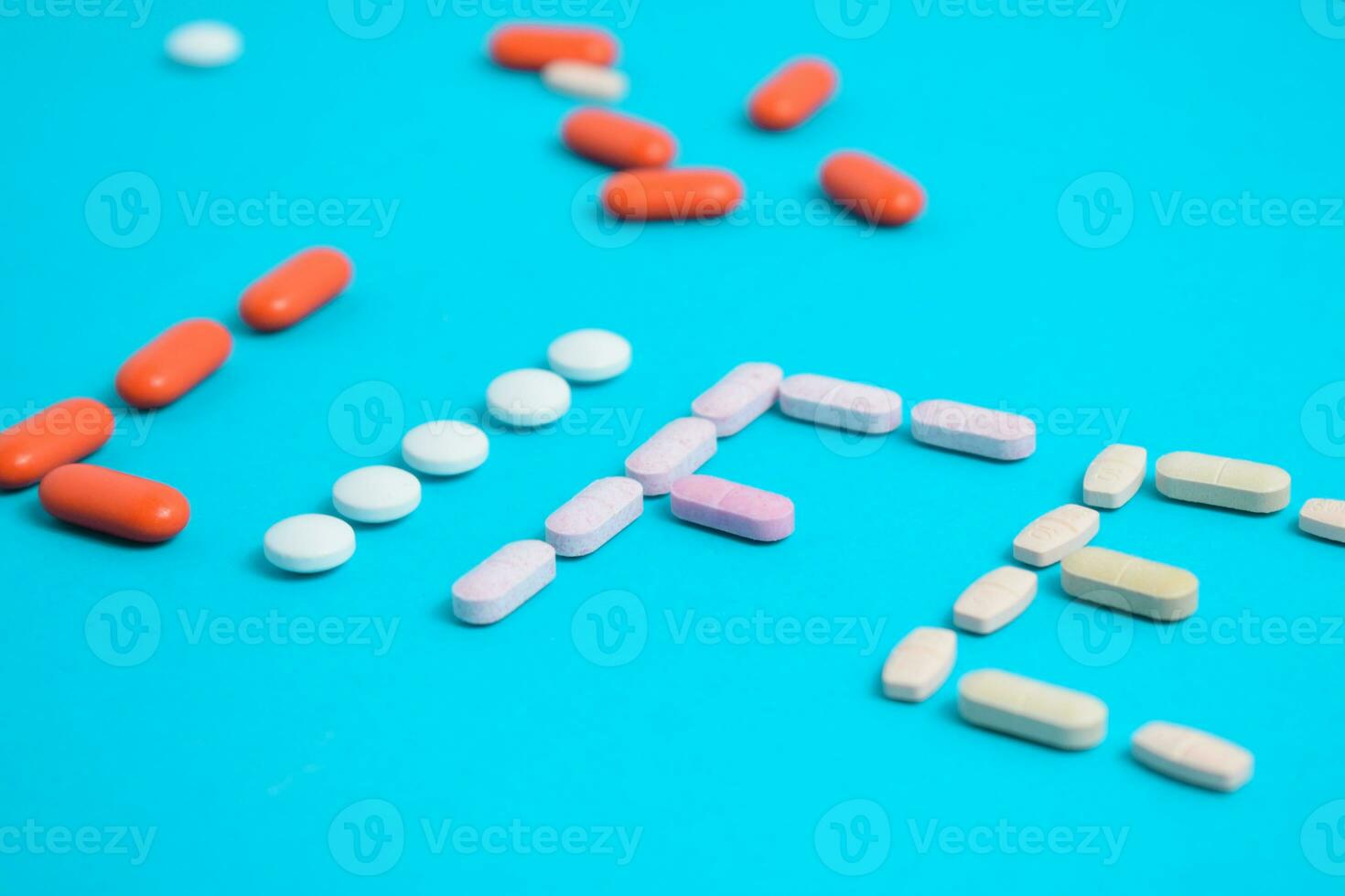 Life word from Colorful Medicine Pills isolated on blue background, supplement, vitamin, colorful photo