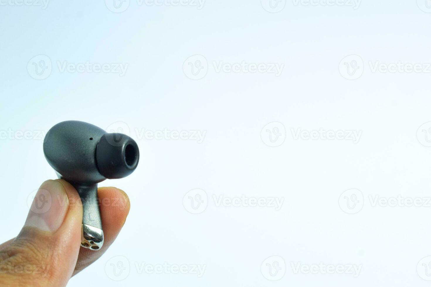 Hand holding TWS or wireless earphone isolated on white background ,True Wireless Stereo, buds, charging. photo