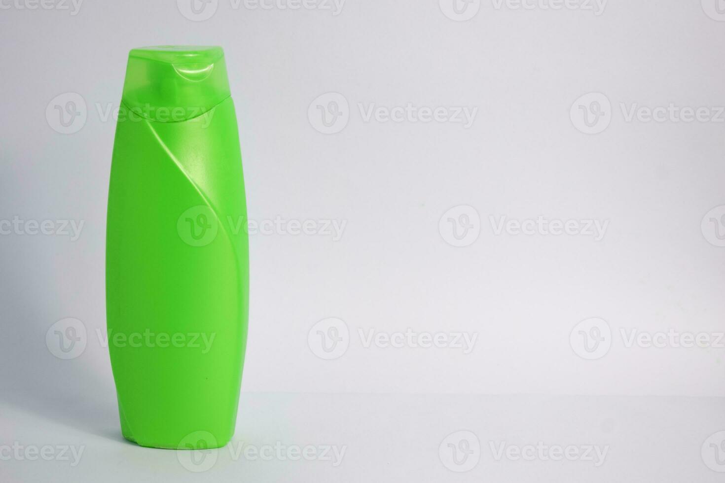 Green blank bottle shampoo minimalist bakcground, hair care bottle mock up product. photo