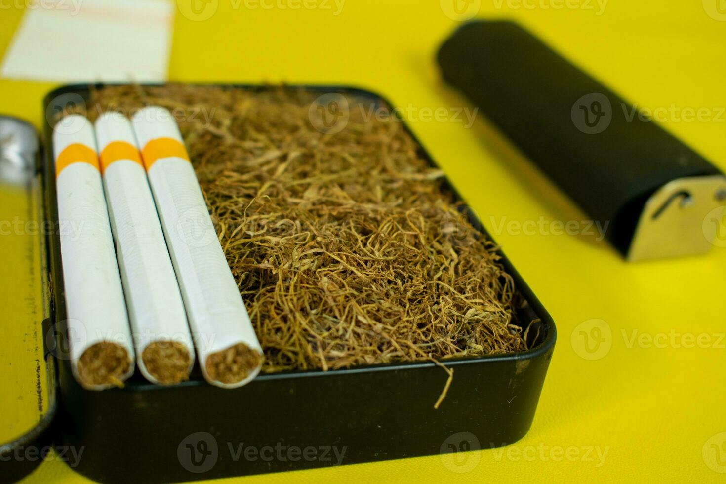 Tobacco and cigarette in black box, cigarette roller handmade photo