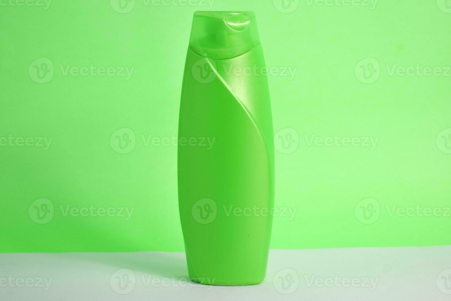 Green blank bottle shampoo minimalist bakcground, hair care bottle mock up product. photo