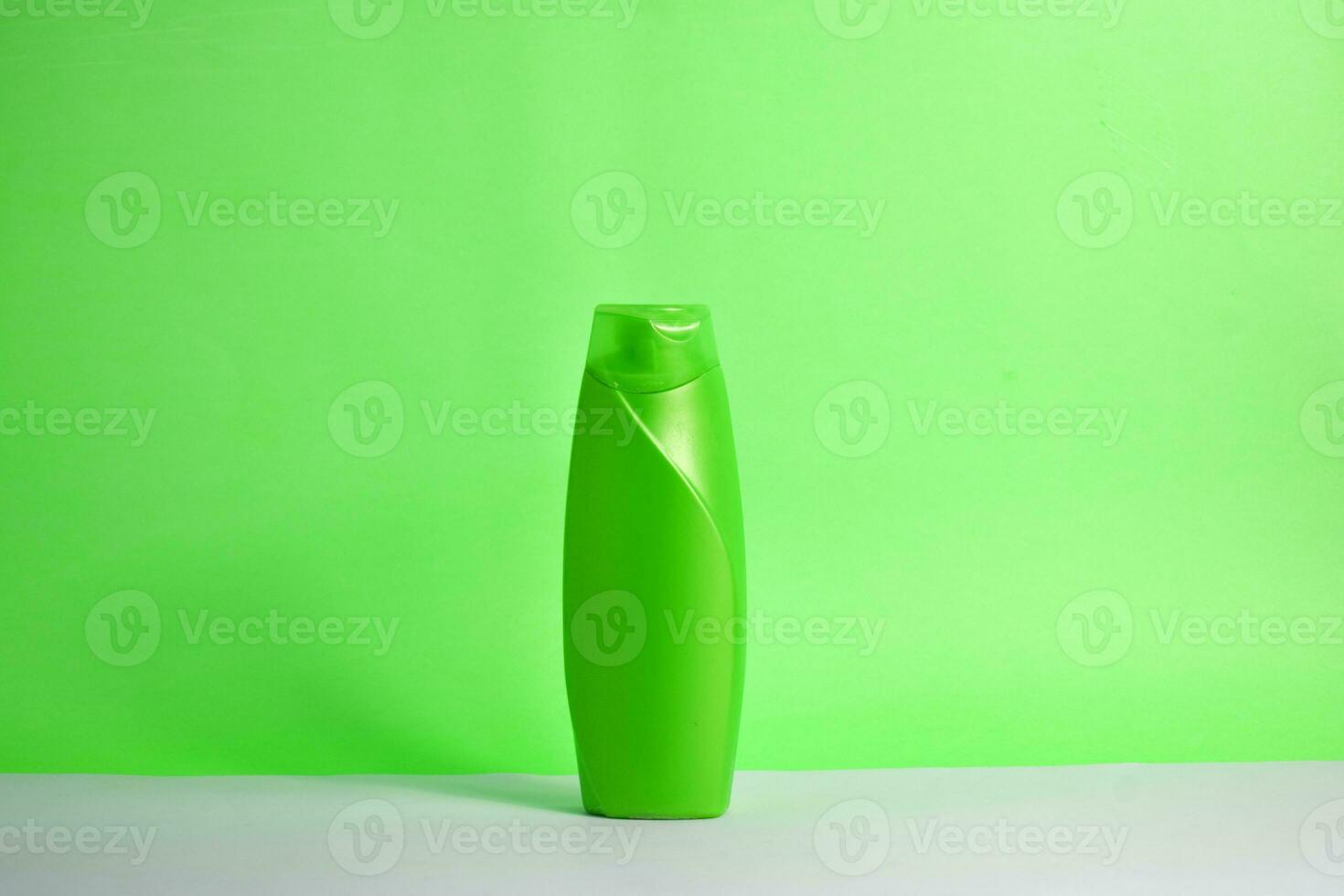 Green blank bottle shampoo minimalist bakcground, hair care bottle mock up product. photo