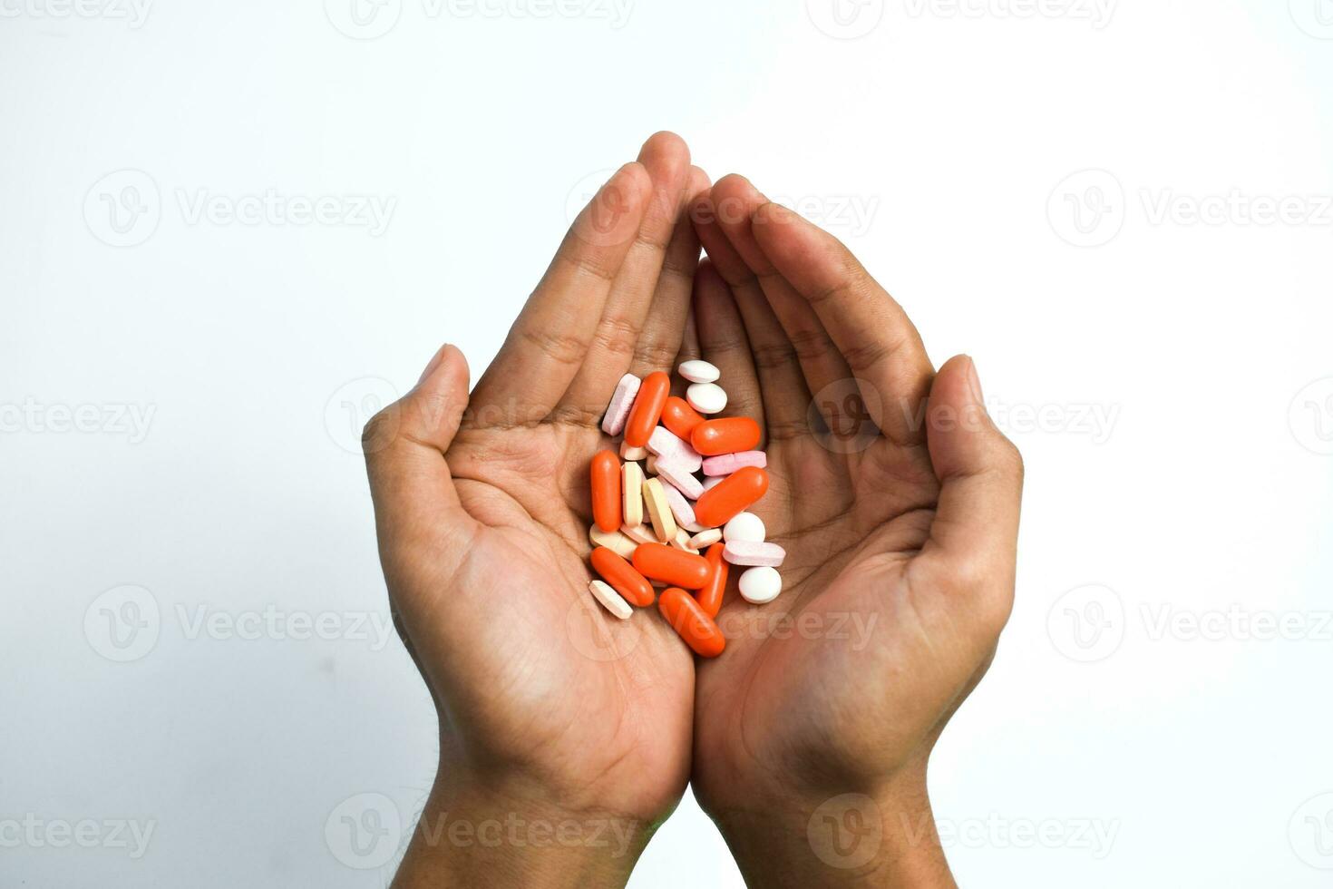 Colorful Medicine pills in man two hands on white background photo