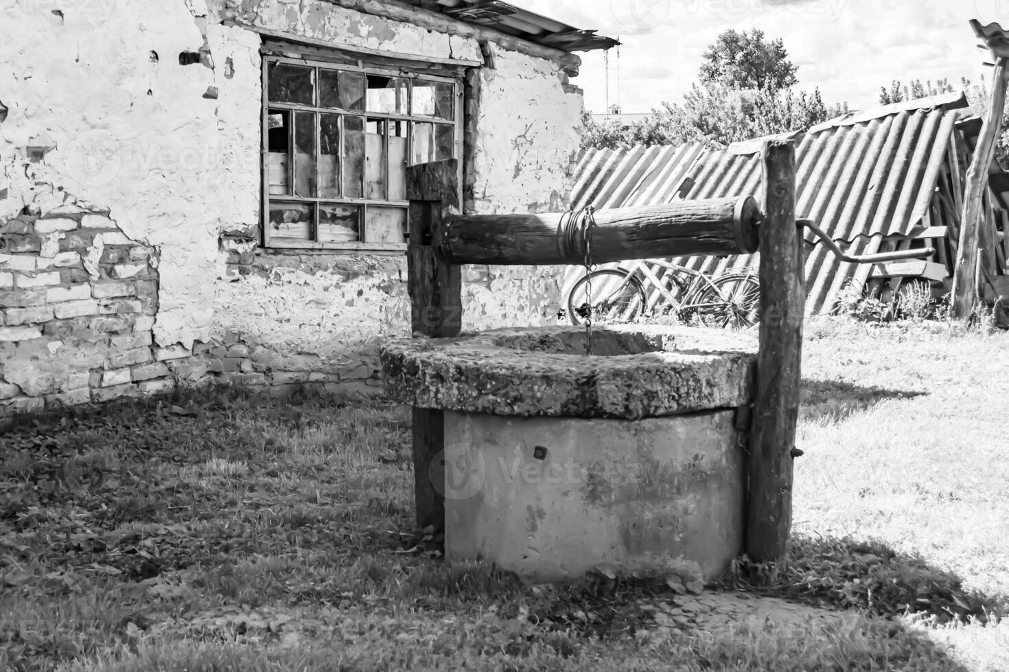 Old well with iron bucket on long forged chain for clean drinking water photo