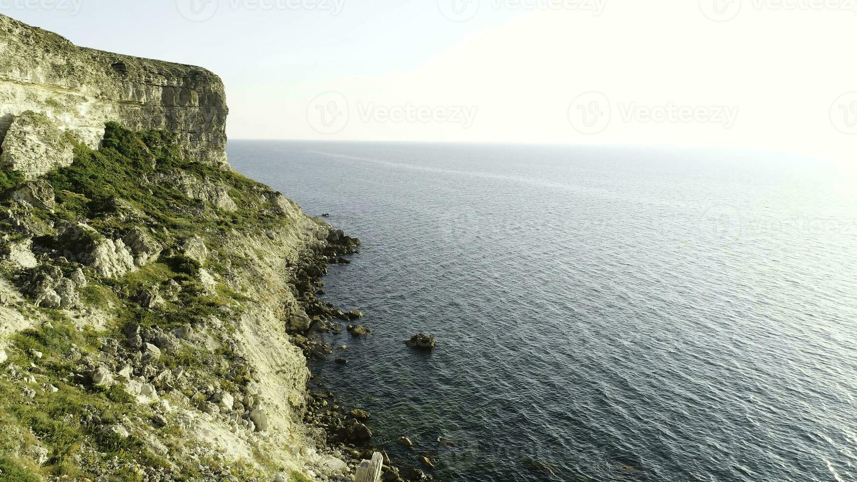 espectacular ver de escarpado acantilados a el océano, Irlanda. disparo. verde Pendiente cerca calma agua y el interminable horizonte en claro azul cielo antecedentes. foto