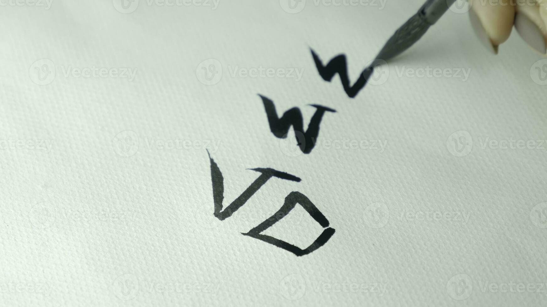 Woman's hands writing Chinese hieroglyph. Female hand holding a writing brush calligraphy Chinese characters, close up photo