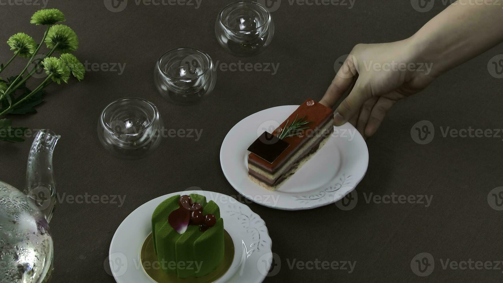 Beautiful transparent teapot kettle with tasty green black tea with apple, with candles and with dessert in the background. Turkish tea in traditional glass on wooden table. Cakes and glass teapot photo
