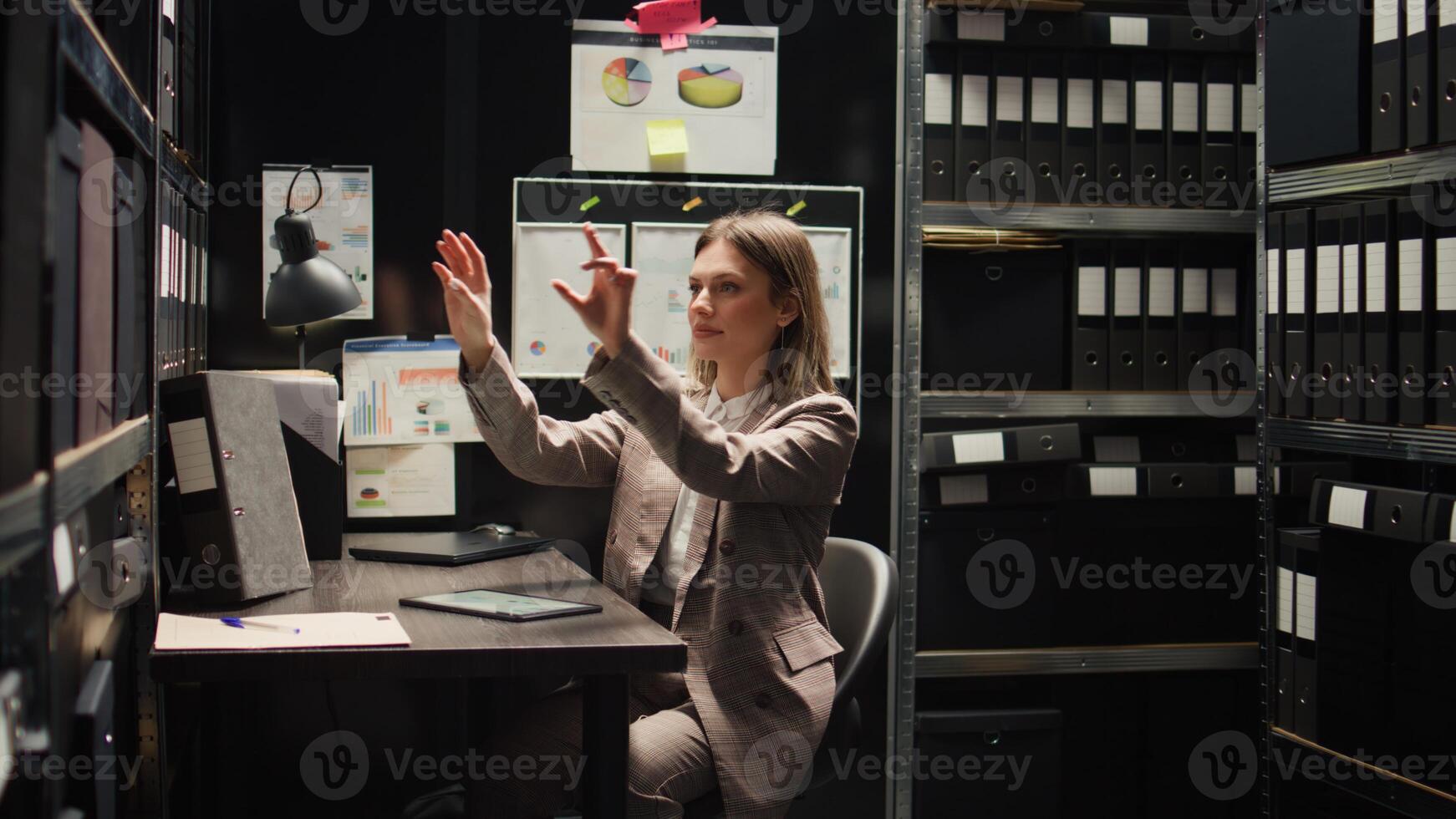 Caucasian female private investigator uses modern technology to analyze holographic clues and criminal records. Police officer using artificial intelligence to move holographic 3D picture of evidence. photo