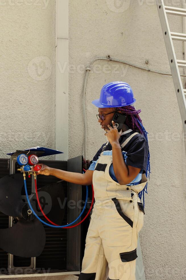 Meticulous mechanic apprentice asking master for advice over the phone about out of order hvac system internal components. Expert checking maintenance plan after refurbishing blower fan photo