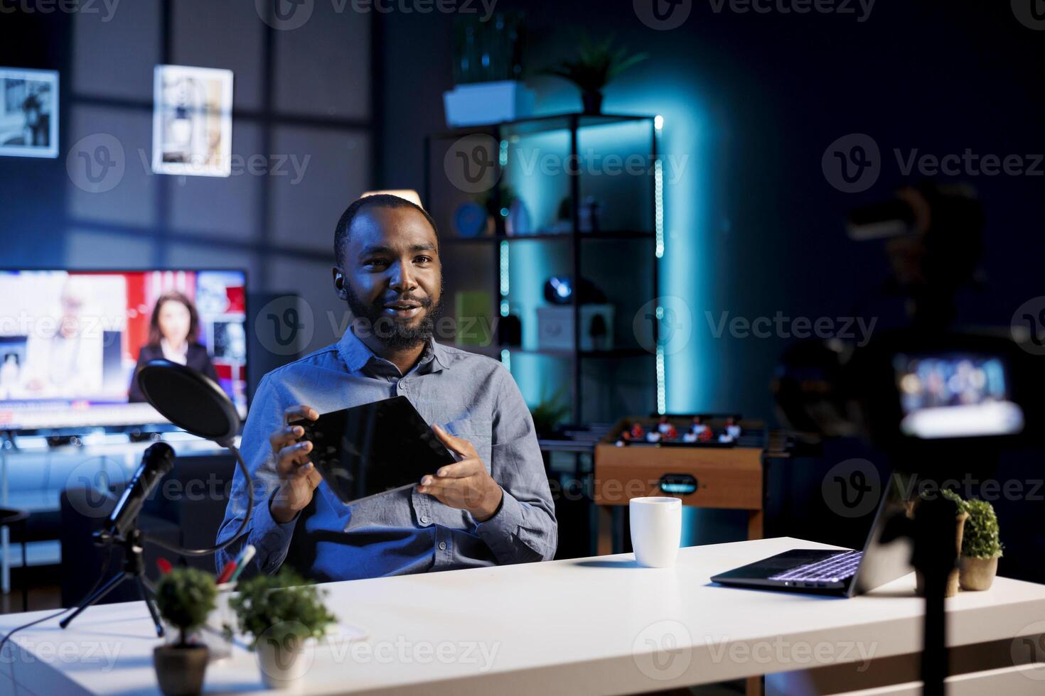 African american man filming tech tutorial on how to do maintenance on broken tablet, presenting internal parts. Technology internet show host teaching subscribers how to open and fix digital device photo
