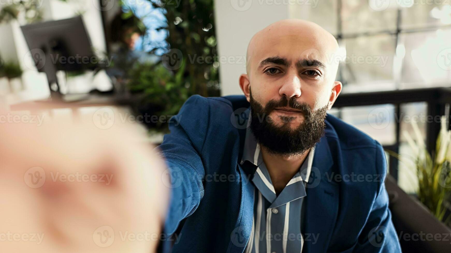 POV of businessman on videocall meeting, attending videoconference online with executive board. Company manager talking on telework call, sitting in coworking space. Handheld shot. photo