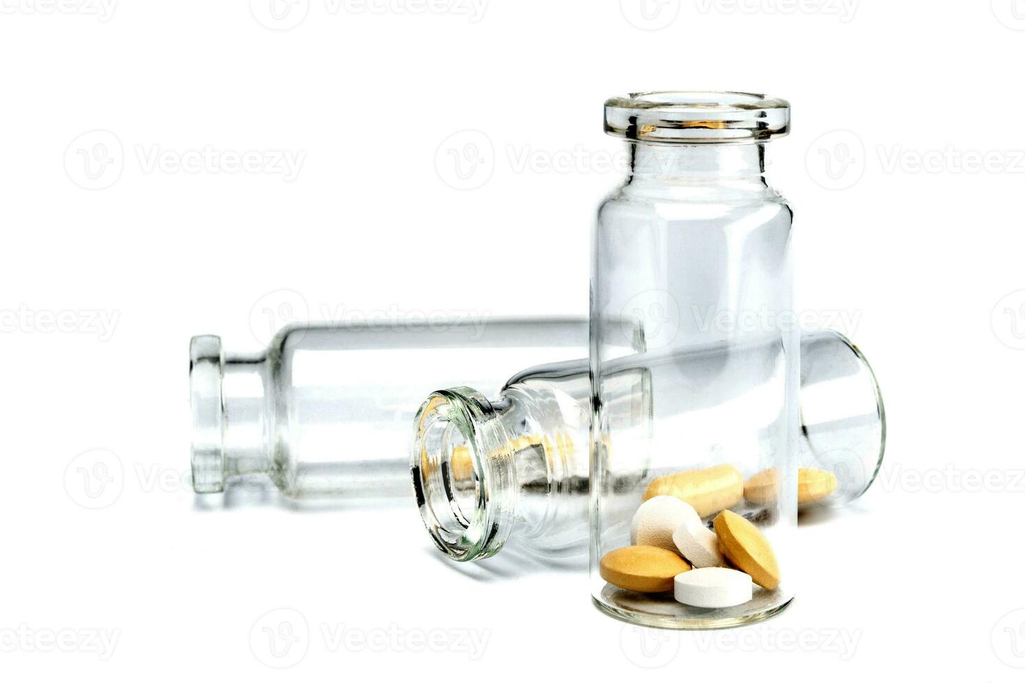 Glass transparent bottles with pills inside. Pills isolated on a white background. photo