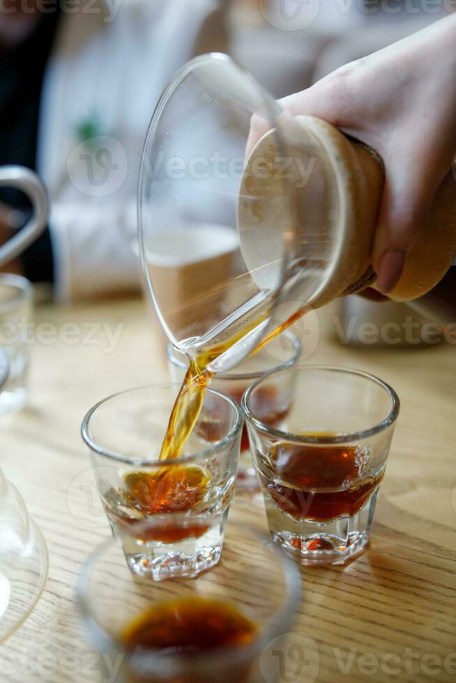 Freshly brewed coffee is poured into glass glasses. photo