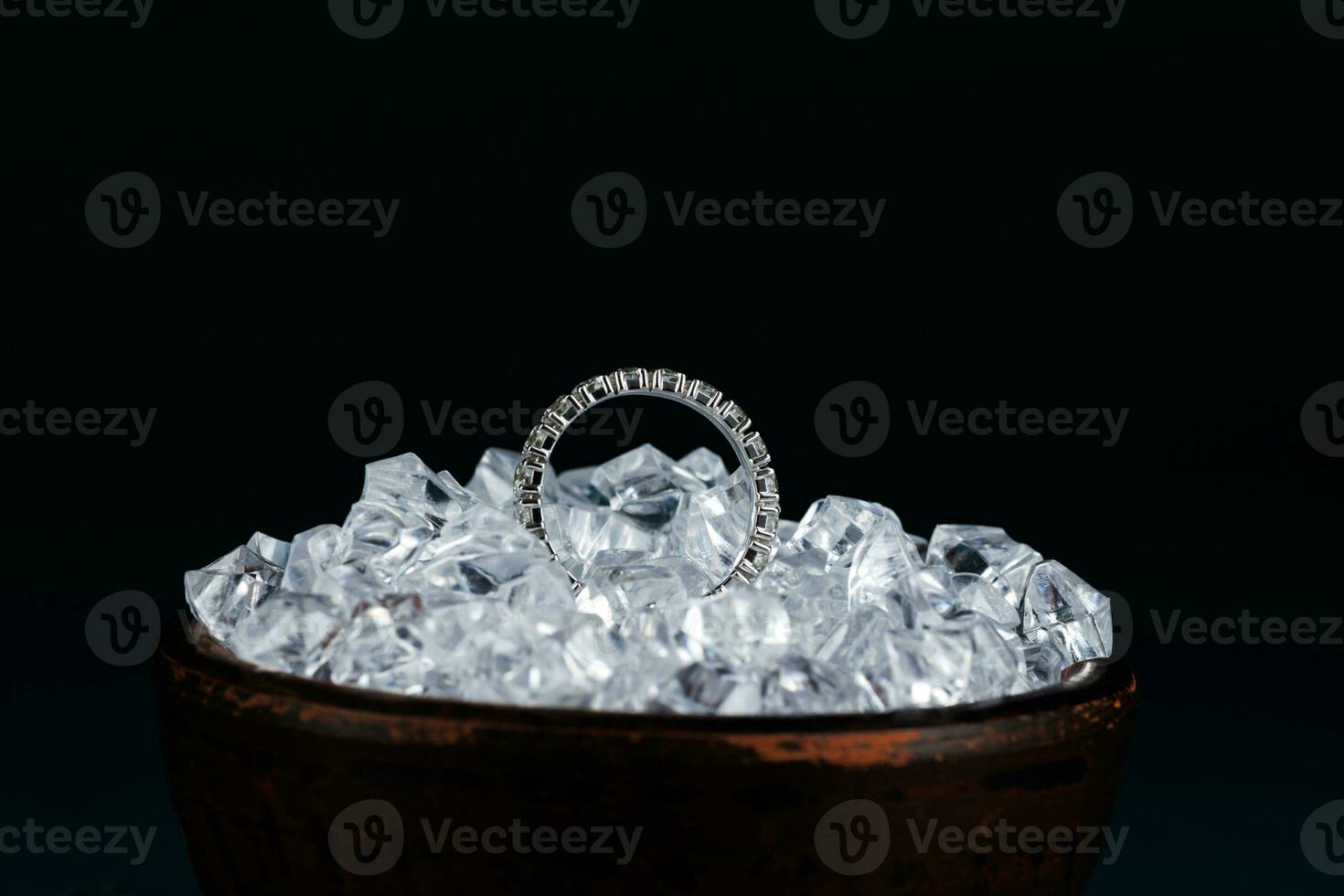 Gold ring with diamond in pieces of ice. photo