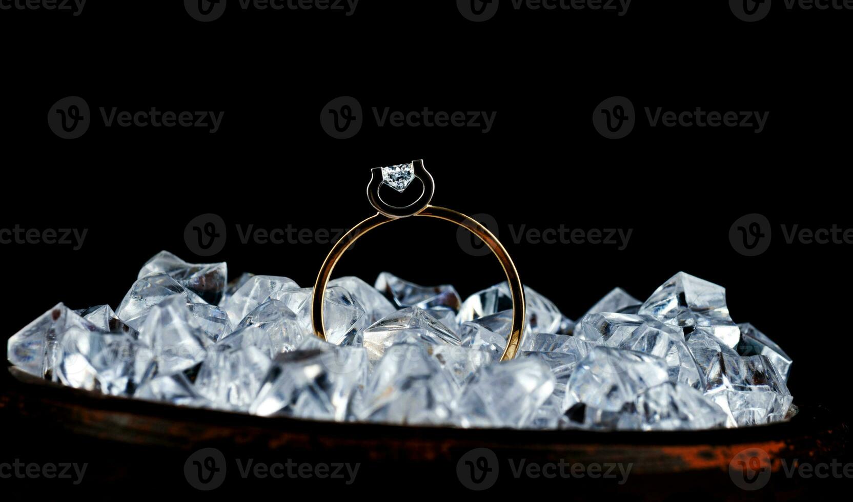 Gold ring with diamond in pieces of ice. photo