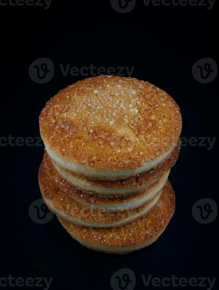 Beautiful round cookies on a black background. A few cookies. Cookie tower. photo