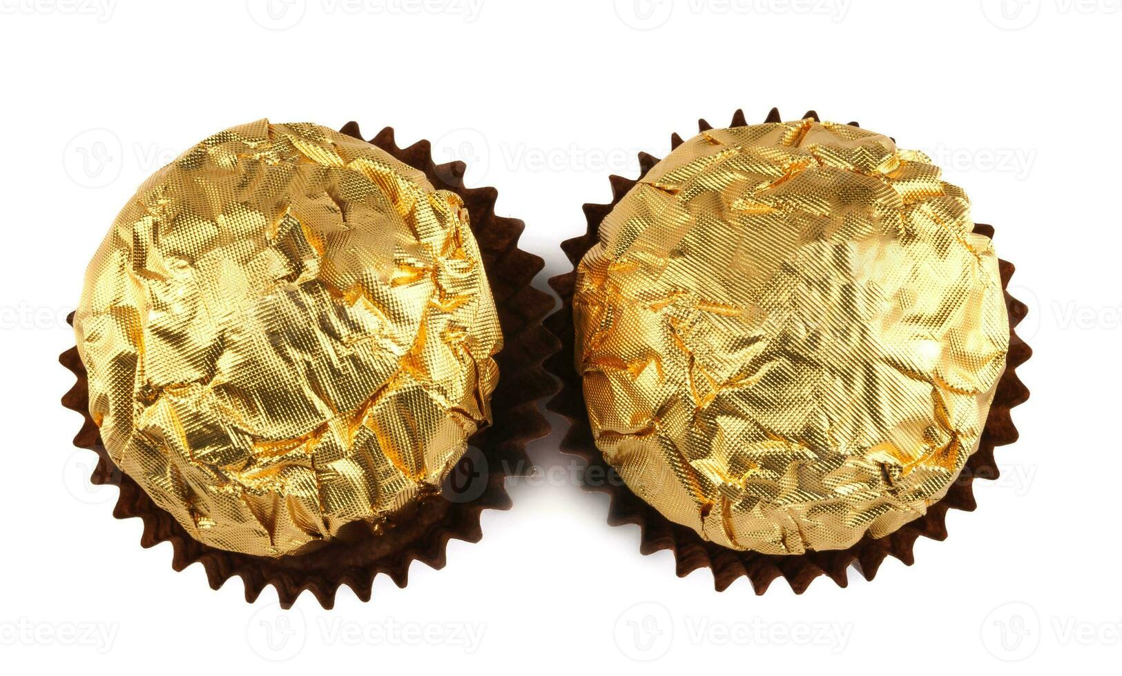 dos chocolate golosinas en un dorado frustrar envoltura aislado en un blanco antecedentes. élite bombones foto