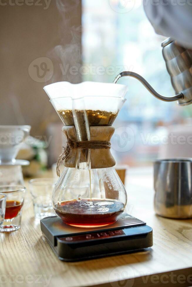 Coffee is brewed in a glass container through a paper filter, an alternative method. photo