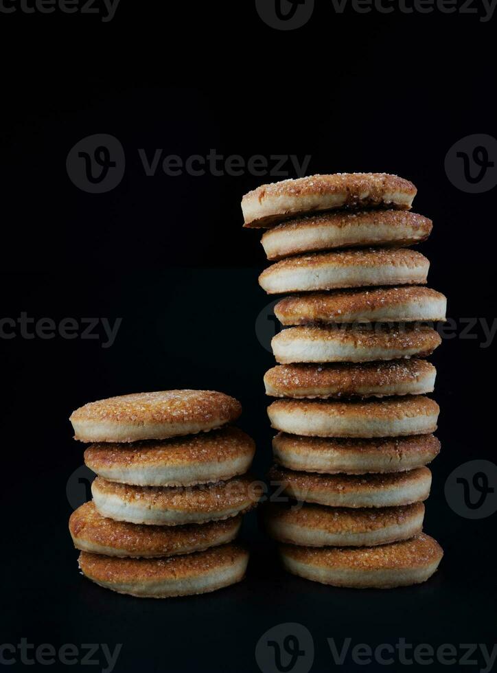 hermosa redondo galletas en un negro antecedentes. un pocos galletas. dos Galleta torres foto