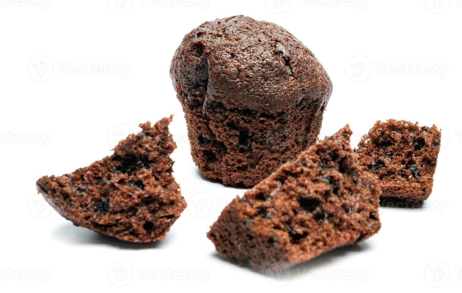 Whole and broken into pieces chocolate muffin isolated on a white background. Chocolate chip muffin. photo
