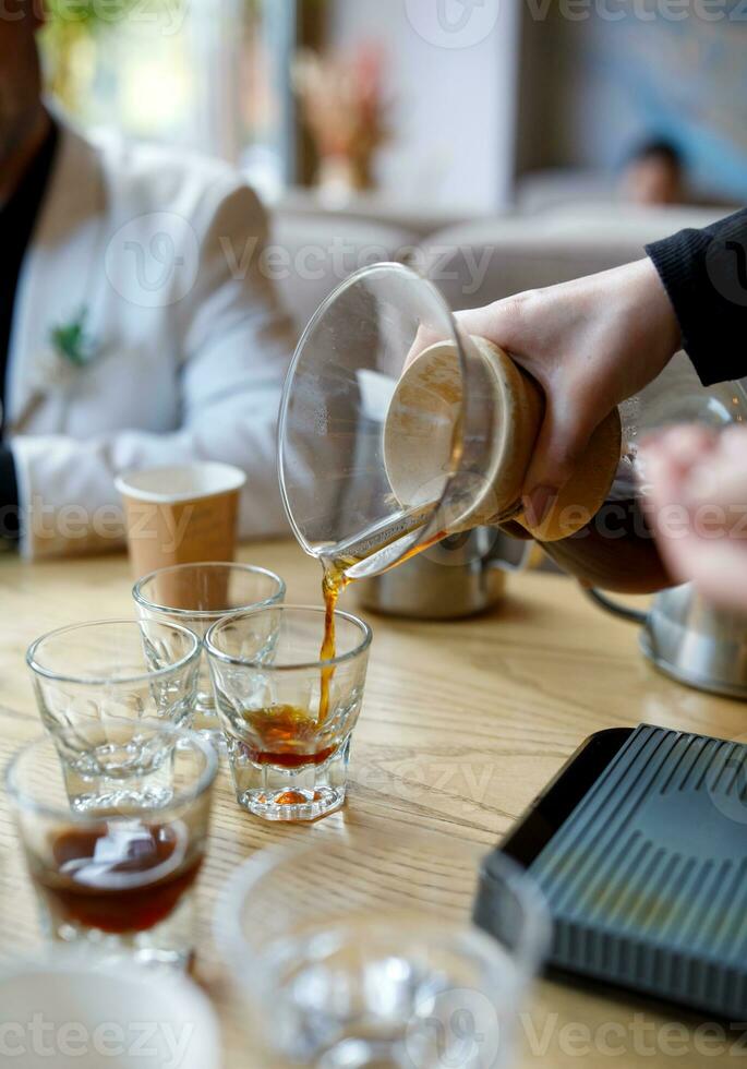 Freshly brewed coffee is poured into glass glasses. photo