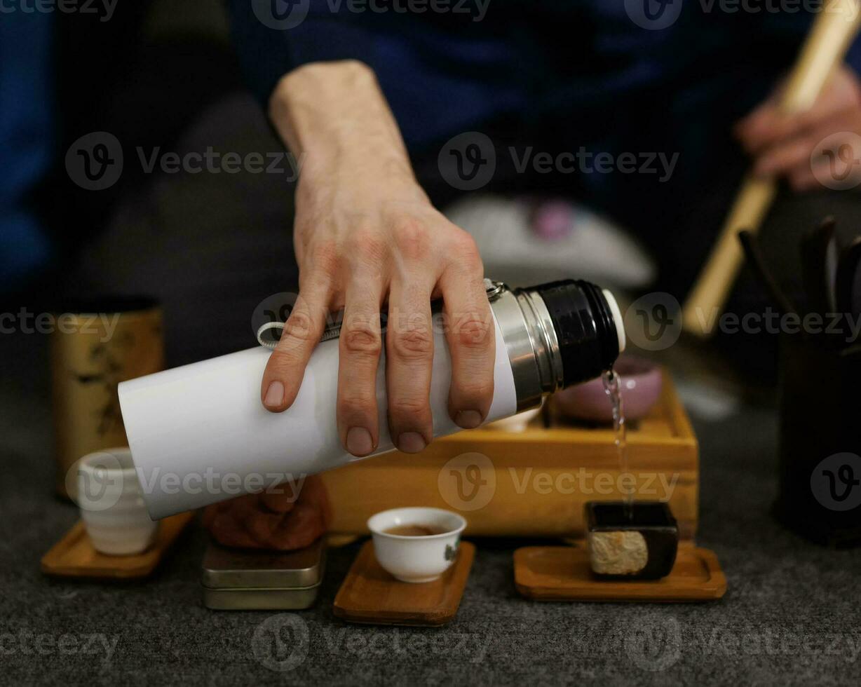 Boiling water pouring from a thermos into a mug. Tea ceremony photo