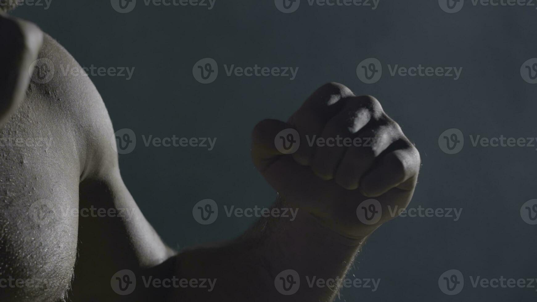 Punches close up in smoke dark background. Muscular kickbox or muay thai fighter punching in smoke. photo