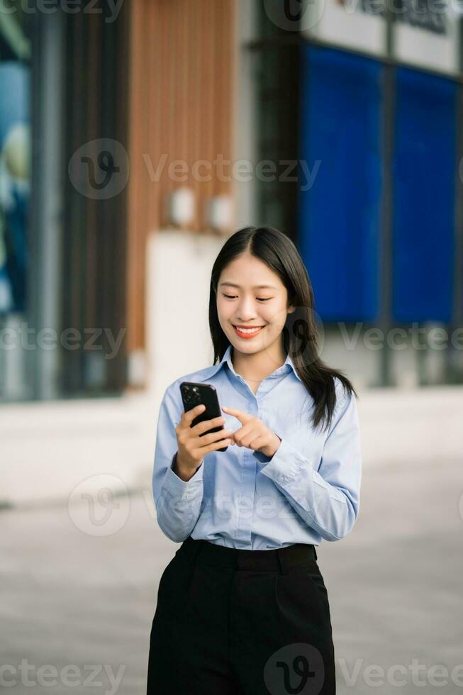 Young Asian business woman leader entrepreneur, professional manager holding digital tablet computer uon the street in big city photo