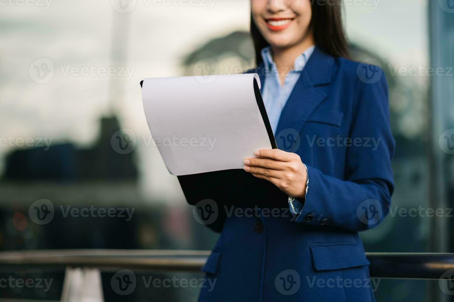 Young Asian business woman leader entrepreneur, professional manager holding digital tablet computer uon the street in big city photo