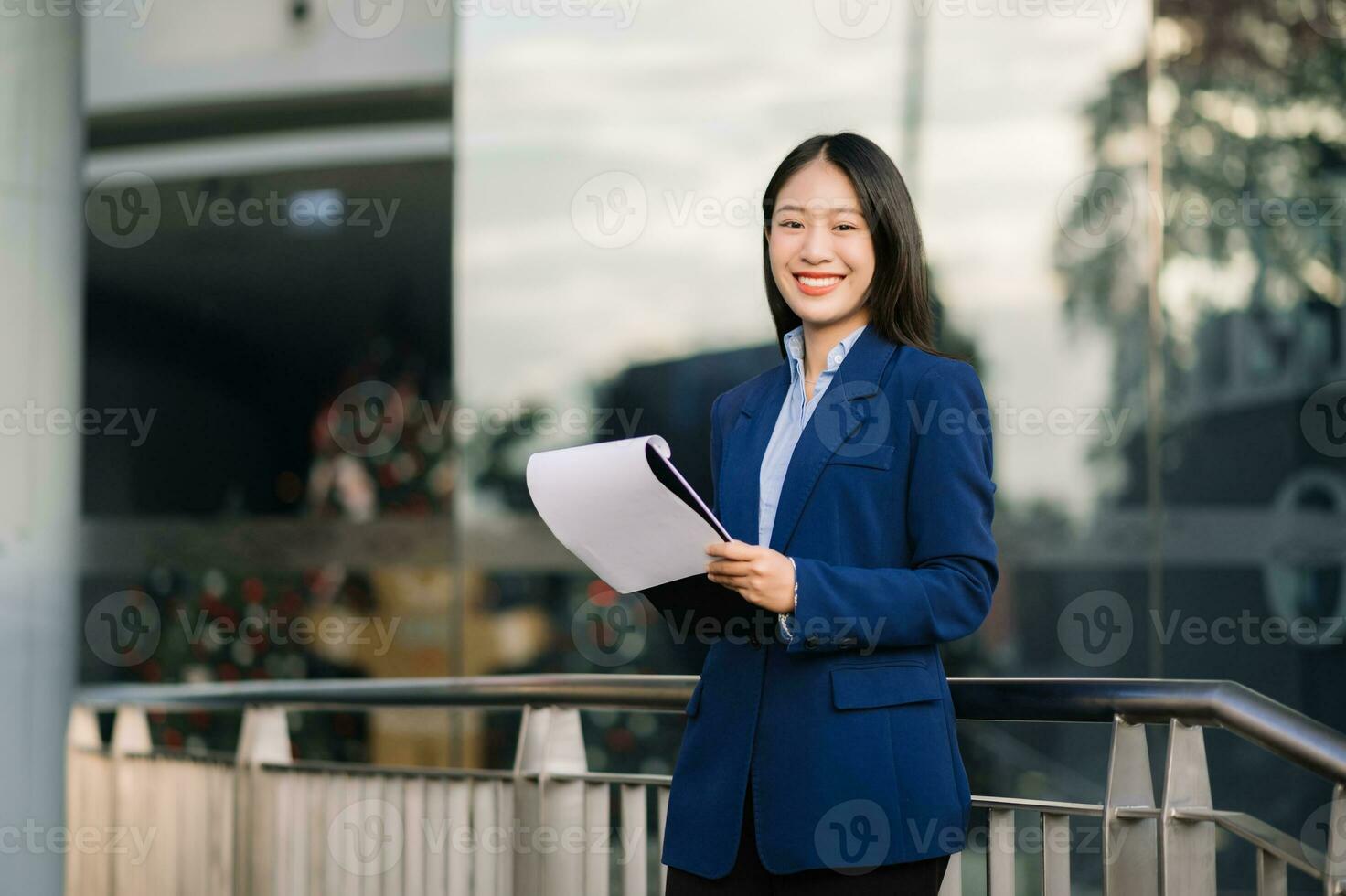 Young Asian business woman leader entrepreneur, professional manager holding digital tablet computer uon the street in big city photo