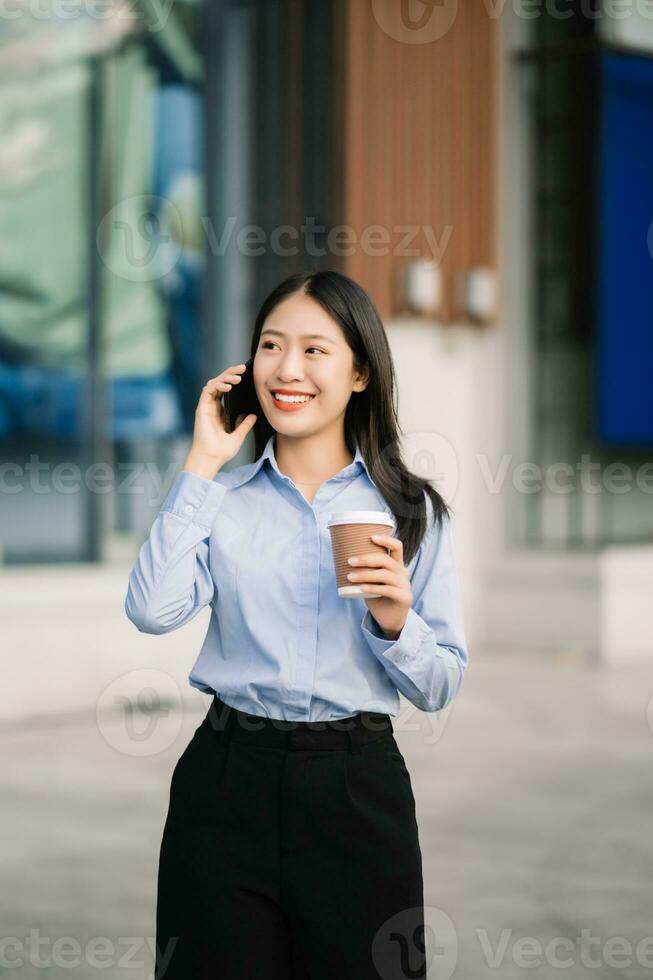 Young Asian business woman leader entrepreneur, professional manager holding digital tablet computer uon the street in big city photo