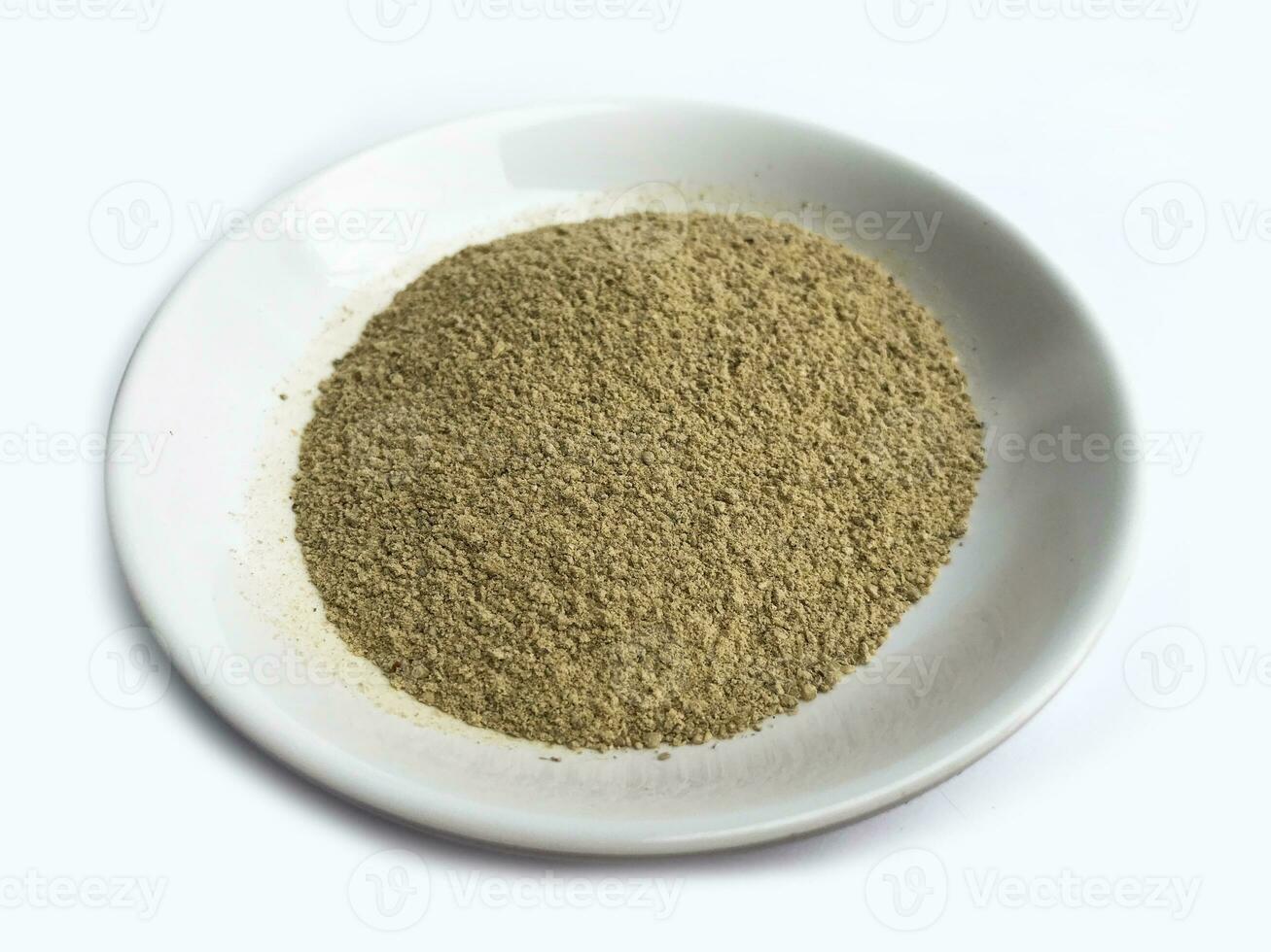 Ground black pepper on a Ceramic plate isolated on a white background. photo