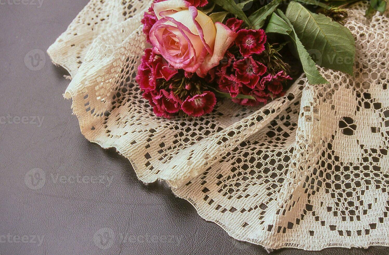 a bouquet of flowers on a lace tablecloth photo