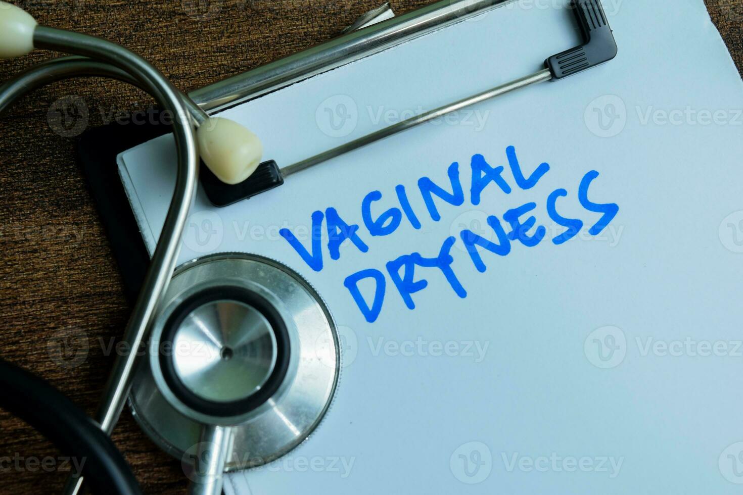 Concept of Vaginal Dryness write on paperwork with stethoscope isolated on wooden background. photo