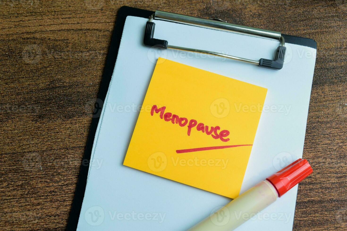 Concept of Menopause write on sticky notes isolated on Wooden Table. photo
