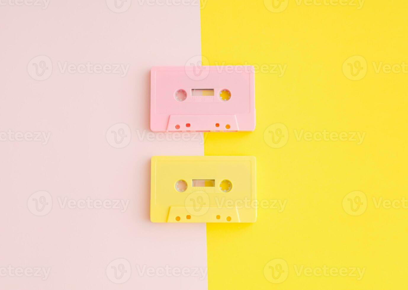 Layout of retro pink and yellow audio cassette tapes on pastel  pink and yellow background. Creative concept of retro technology. 80's aesthetic. Vintage audio cassette tape idea. Retro nostalgia. photo